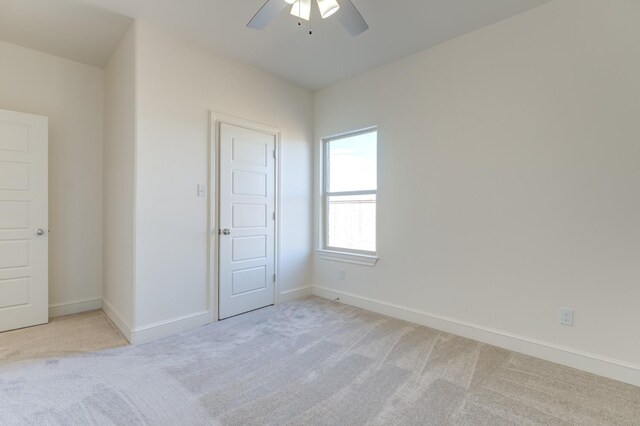 spare room featuring light carpet and ceiling fan