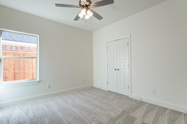 unfurnished room featuring light carpet, ceiling fan, and a healthy amount of sunlight