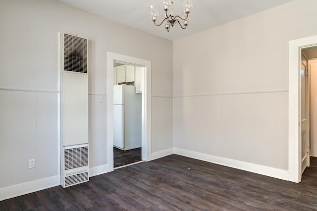 unfurnished bedroom with dark wood-type flooring, a chandelier, and white fridge