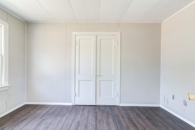 empty room with ornamental molding and dark hardwood / wood-style flooring