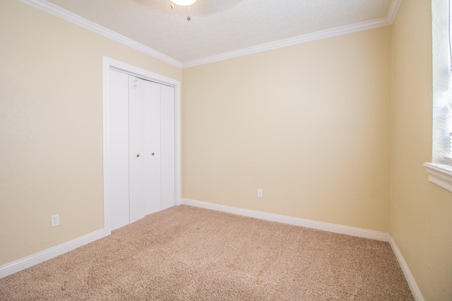 unfurnished bedroom featuring crown molding, a closet, ceiling fan, and carpet