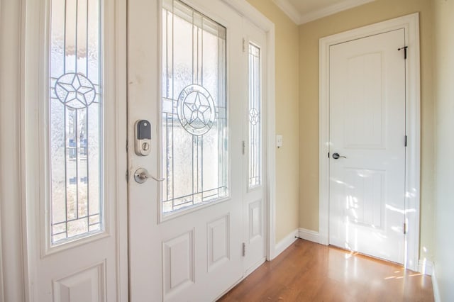 foyer entrance with crown molding and hardwood / wood-style flooring