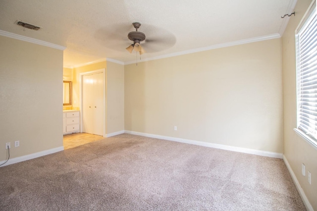 carpeted spare room featuring ornamental molding, a textured ceiling, and ceiling fan