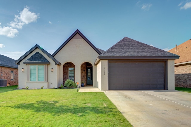 view of front of home with a garage, a front yard, and central AC unit