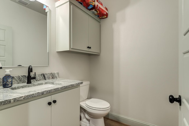 bathroom featuring vanity, toilet, and hardwood / wood-style floors