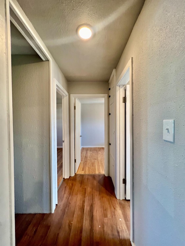 hallway featuring hardwood / wood-style flooring and a textured ceiling