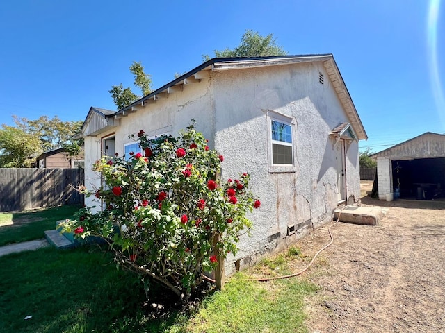 view of property exterior with a garage and an outbuilding