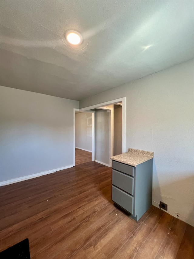 interior space featuring dark hardwood / wood-style flooring and a textured ceiling