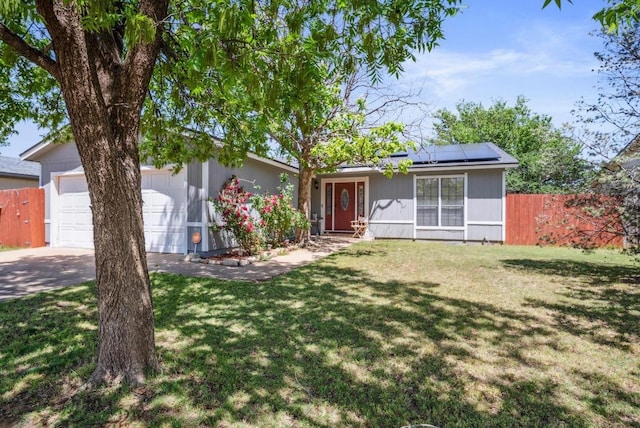 single story home featuring a garage, a front lawn, and solar panels