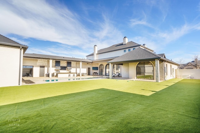 back of house featuring a swimming pool, a patio area, and a lawn