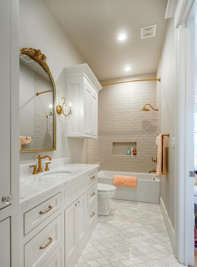 full bathroom with vanity, toilet, and tiled shower / bath