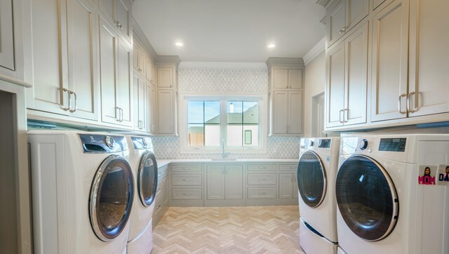 laundry area with light parquet floors, ornamental molding, cabinets, and independent washer and dryer