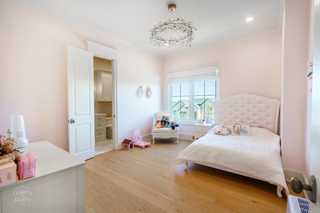 bedroom featuring crown molding, hardwood / wood-style floors, and ensuite bathroom