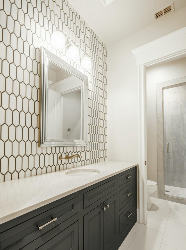 bathroom with backsplash, vanity, an enclosed shower, tile patterned floors, and toilet