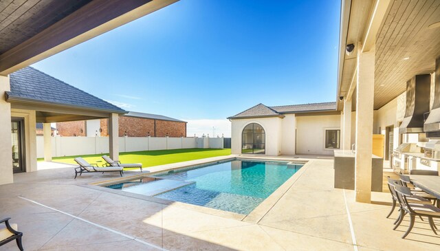 view of swimming pool with exterior kitchen, an in ground hot tub, a patio, and exterior bar