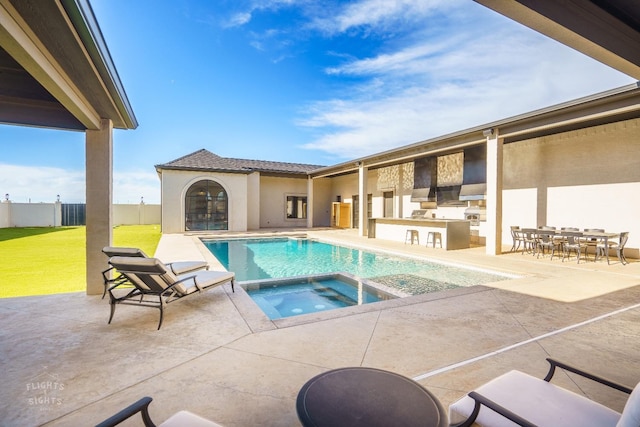 view of swimming pool with an outdoor kitchen, a lawn, an outdoor bar, an in ground hot tub, and a patio