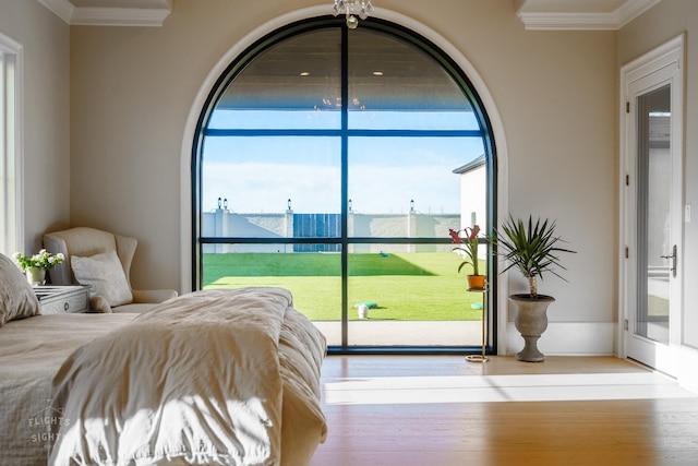 bedroom with access to exterior, ornamental molding, and light hardwood / wood-style floors