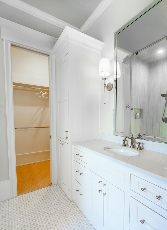 bathroom featuring vanity, ornamental molding, and walk in shower