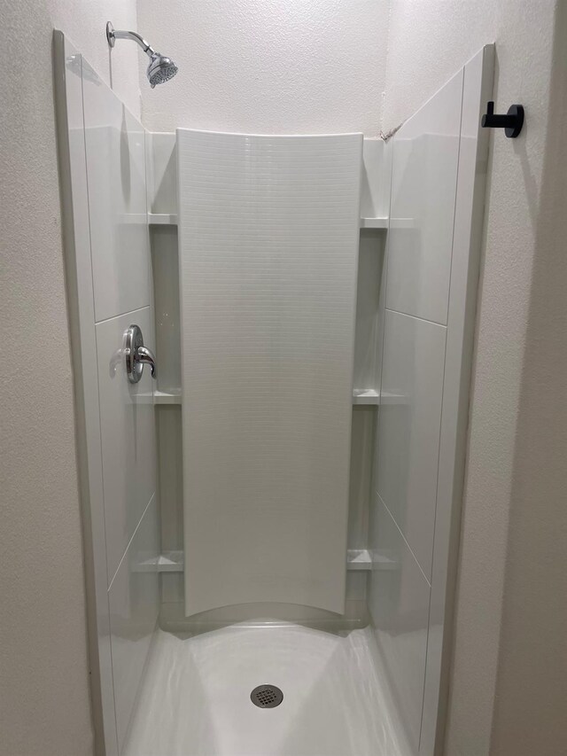 bathroom featuring a textured ceiling and a shower