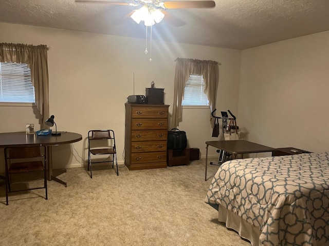 carpeted bedroom featuring ceiling fan and a textured ceiling