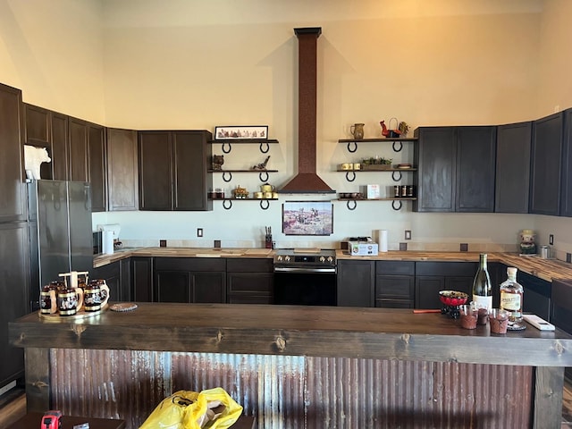 kitchen featuring stainless steel appliances, island exhaust hood, a towering ceiling, and dark brown cabinetry