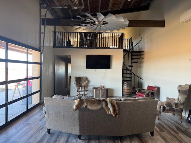 living room with a wall mounted air conditioner, beamed ceiling, wood-type flooring, a high ceiling, and ceiling fan