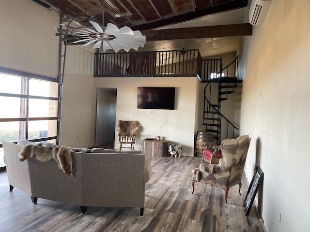 living room with a high ceiling, wood-type flooring, a wall mounted AC, and beam ceiling