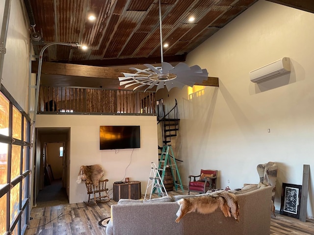 living room featuring hardwood / wood-style flooring, an AC wall unit, ceiling fan, and a high ceiling