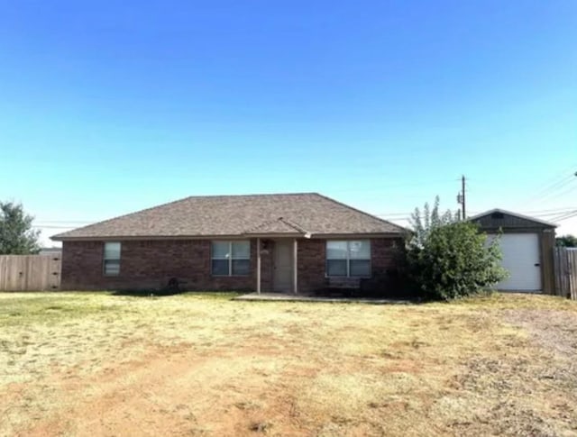 view of front of house featuring a garage, an outdoor structure, and a front lawn