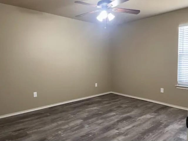 spare room with dark wood-type flooring and ceiling fan