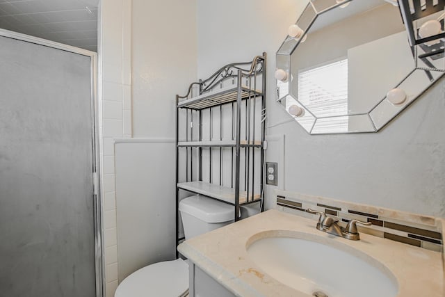 full bathroom with a shower stall, vanity, and toilet