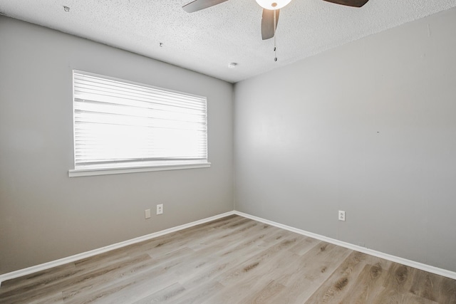spare room with a textured ceiling, wood finished floors, and a ceiling fan