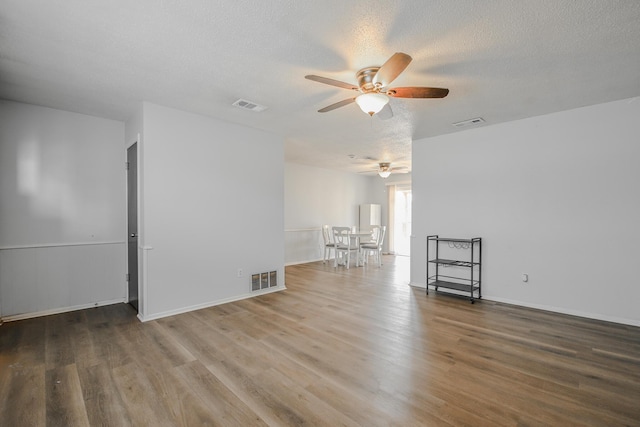 unfurnished room featuring visible vents, a ceiling fan, and wood finished floors