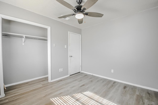 unfurnished bedroom featuring a closet, baseboards, ceiling fan, and wood finished floors