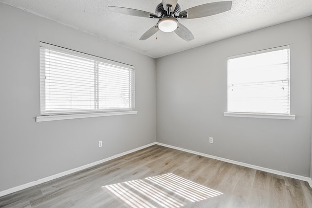 spare room featuring wood finished floors, baseboards, and a ceiling fan