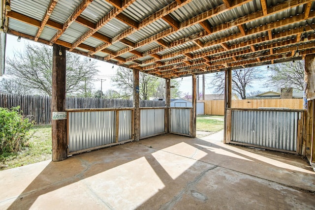 view of patio featuring a fenced backyard, an outdoor structure, and a shed