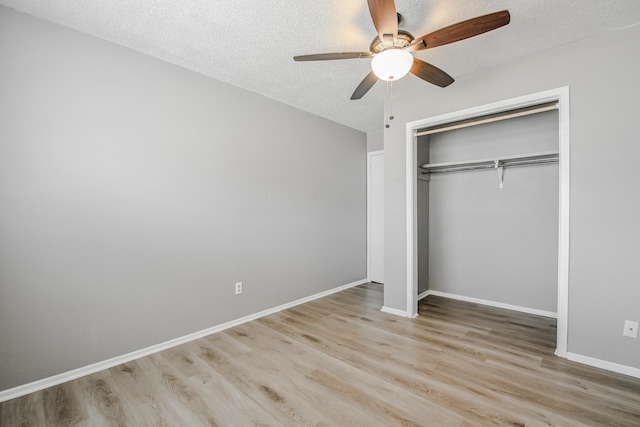 unfurnished bedroom featuring a closet, wood finished floors, and a textured ceiling