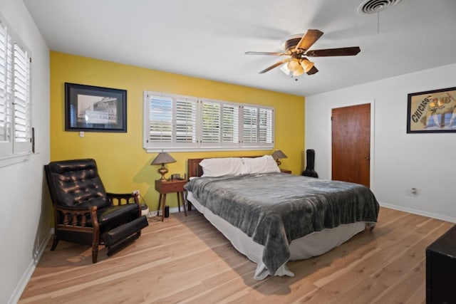 bedroom featuring multiple windows, light hardwood / wood-style floors, and ceiling fan