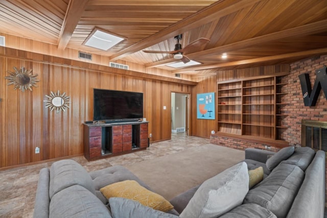 living room featuring a skylight, wood walls, ceiling fan, wood ceiling, and beam ceiling