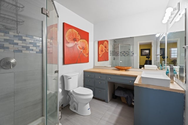 bathroom featuring vanity, toilet, and a shower with shower door