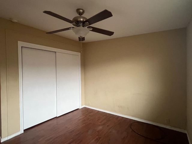 unfurnished bedroom featuring dark wood-type flooring, a closet, and ceiling fan