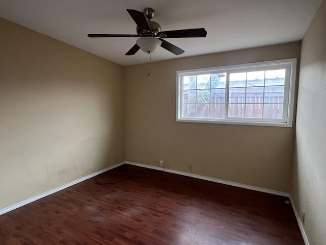 empty room with ceiling fan and dark hardwood / wood-style flooring