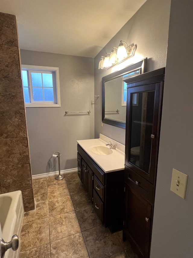 bathroom featuring a tub to relax in, vanity, and tile patterned floors