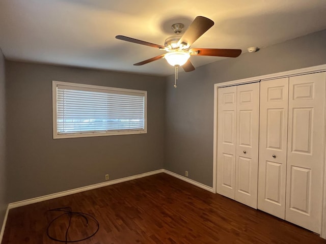 unfurnished bedroom featuring dark hardwood / wood-style flooring, a closet, and ceiling fan