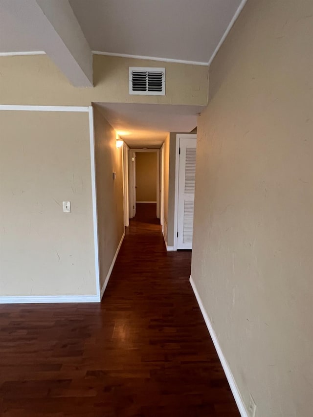 hallway with dark hardwood / wood-style flooring and crown molding