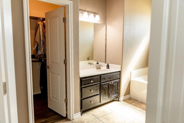 bathroom featuring tile patterned flooring, vanity, and a bathing tub