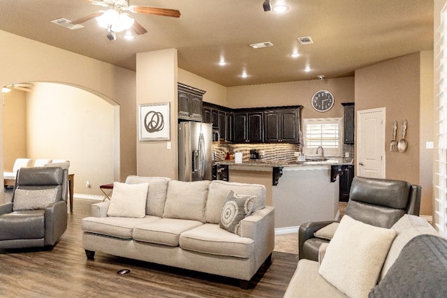 living room featuring wood-type flooring, sink, and ceiling fan