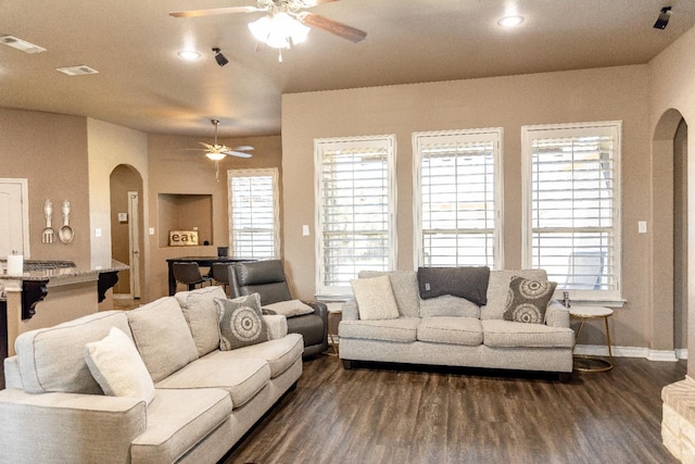 living room featuring dark wood-type flooring and ceiling fan