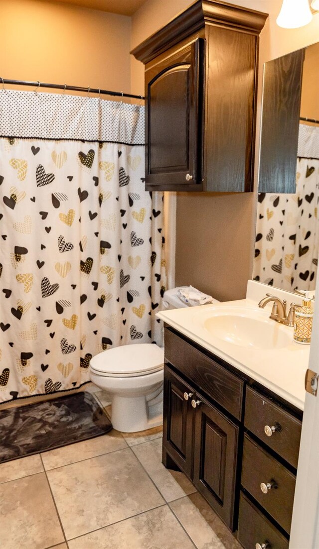 bathroom featuring vanity, curtained shower, tile patterned floors, and toilet