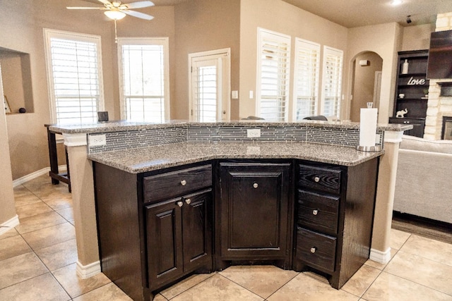 kitchen with a wealth of natural light, dark brown cabinetry, and light tile patterned floors